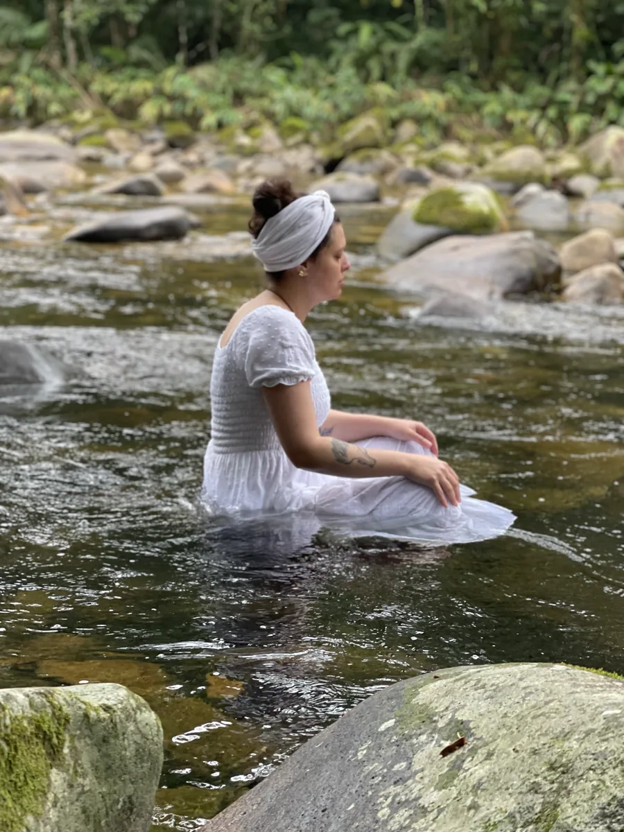 Mulher de branco em banho de rio, em momento de renovação espiritual da Jacutá
